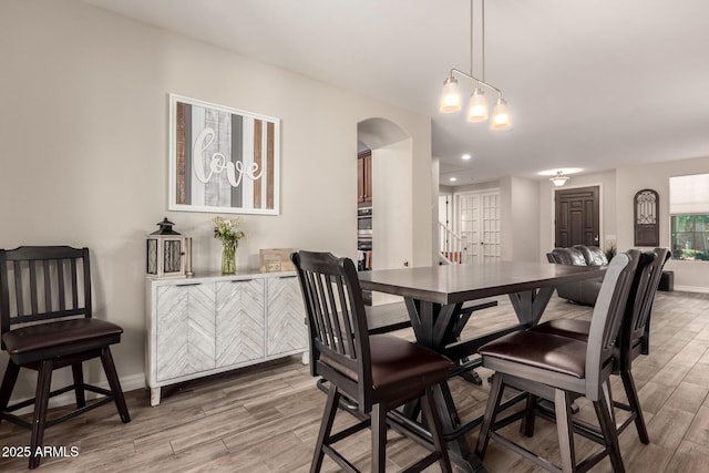 1217 W Fever Tree Ave, San Tan Valley, AZ 85140 - dining space with light wood-type flooring, arched walkways, baseboards, and recessed lighting
