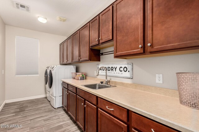1217 W Fever Tree Ave, San Tan Valley, AZ 85140 - clothes washing area with washing machine and dryer, cabinet space, light wood-style floors, and baseboards