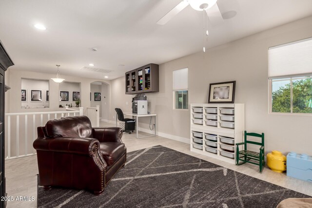 1217 W Fever Tree Ave, San Tan Valley, AZ 85140 - living area with wood finished floors, arched walkways, a ceiling fan, recessed lighting, and baseboards