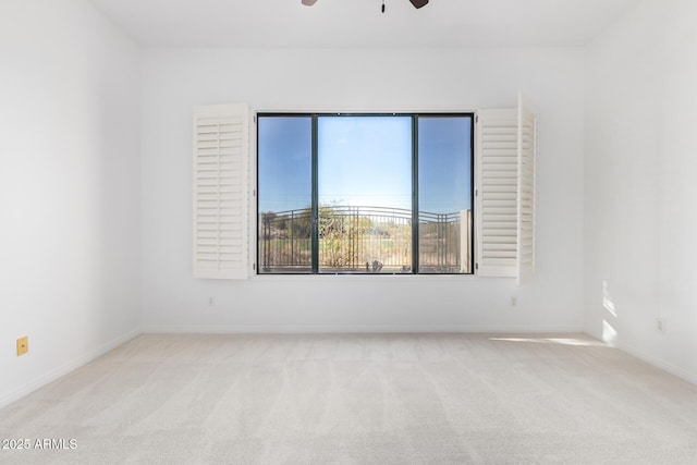 empty room featuring ceiling fan and light colored carpet