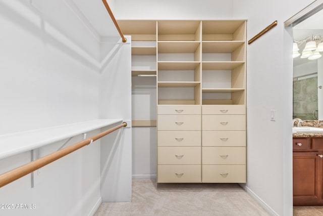 walk in closet with light carpet and sink