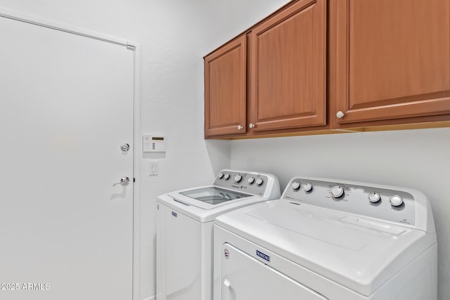 laundry area featuring cabinets and washer and clothes dryer