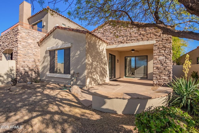 back of property with ceiling fan and a patio