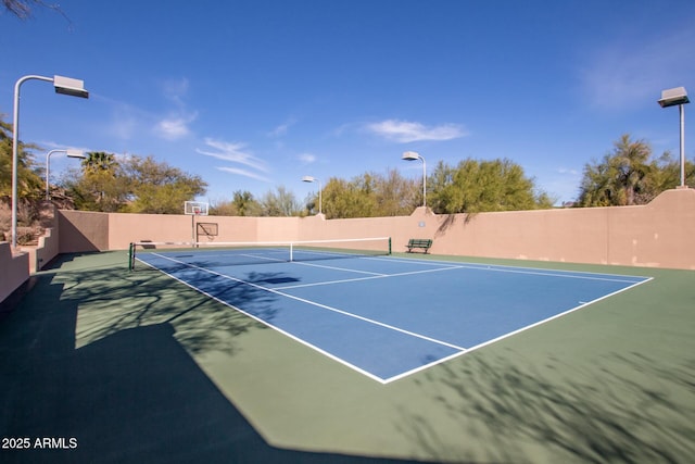 view of tennis court with basketball hoop