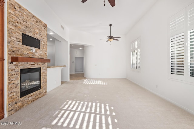 unfurnished living room featuring light carpet, ceiling fan, and a fireplace