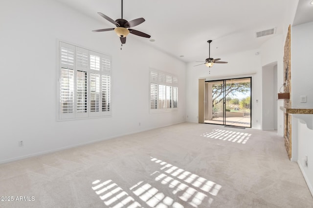 unfurnished living room featuring light carpet and a towering ceiling