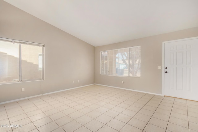 tiled spare room featuring vaulted ceiling and plenty of natural light