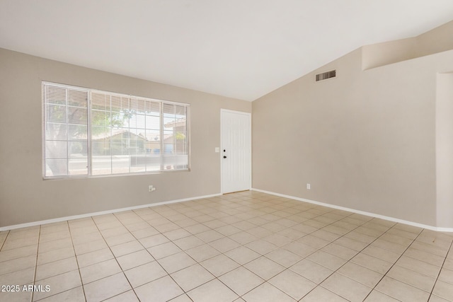 unfurnished room with vaulted ceiling and light tile patterned floors