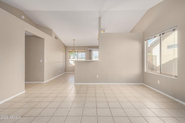 unfurnished room with an inviting chandelier, lofted ceiling, and light tile patterned floors