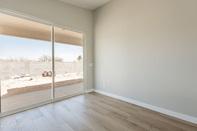 empty room with light wood-style flooring and baseboards