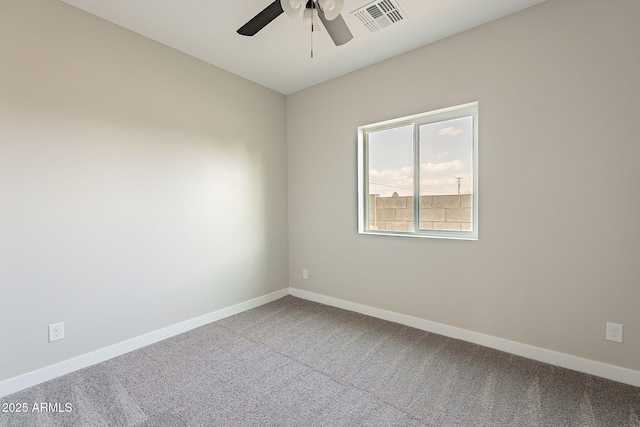 carpeted spare room featuring visible vents, ceiling fan, and baseboards