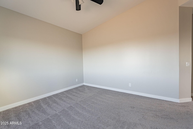 spare room with vaulted ceiling, carpet flooring, a ceiling fan, and baseboards