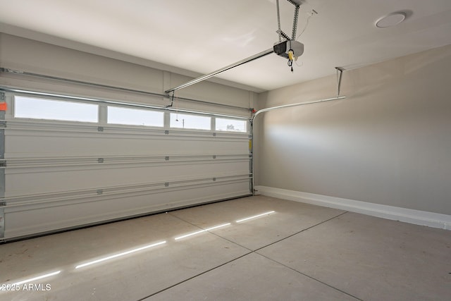 garage featuring a garage door opener and baseboards