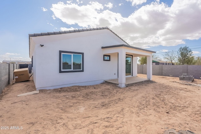 rear view of house with a patio, a fenced backyard, and stucco siding