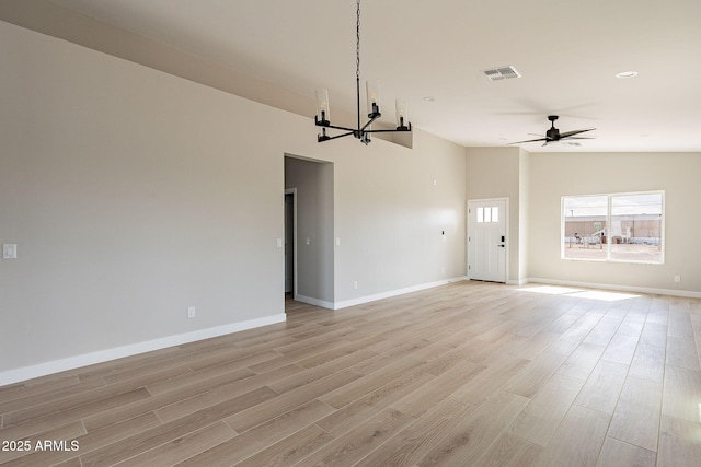 interior space with lofted ceiling, light wood-style flooring, visible vents, and ceiling fan with notable chandelier