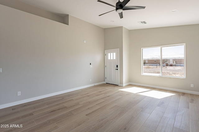 interior space featuring baseboards, light wood finished floors, visible vents, and a ceiling fan