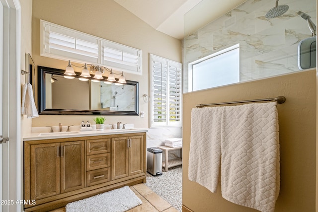 bathroom featuring vanity, lofted ceiling, and a shower