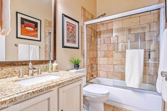 full bathroom with enclosed tub / shower combo, vanity, and toilet