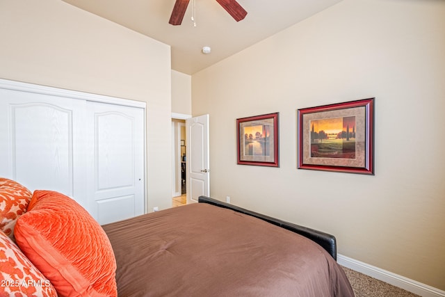 carpeted bedroom with ceiling fan and a closet