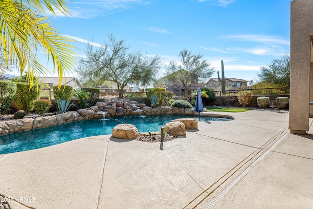 view of swimming pool with pool water feature and a patio