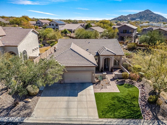 view of front of house with a garage, a mountain view, and a front lawn