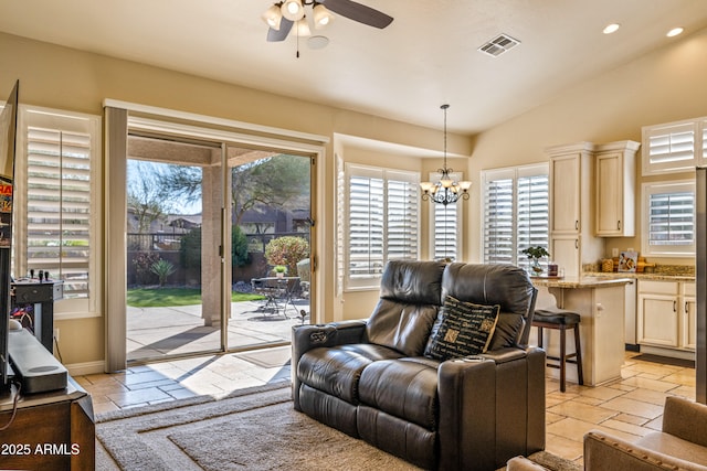 living room with lofted ceiling and ceiling fan with notable chandelier