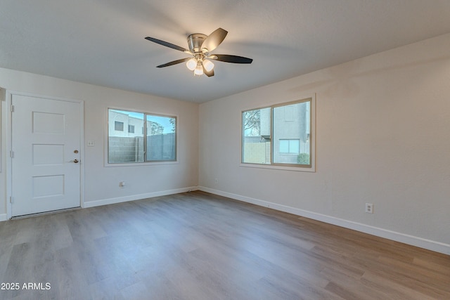 unfurnished room with ceiling fan, a healthy amount of sunlight, and light wood-type flooring