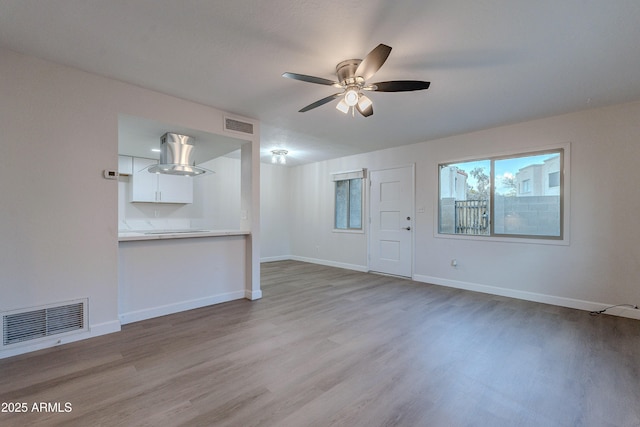 unfurnished living room featuring ceiling fan and light wood-type flooring