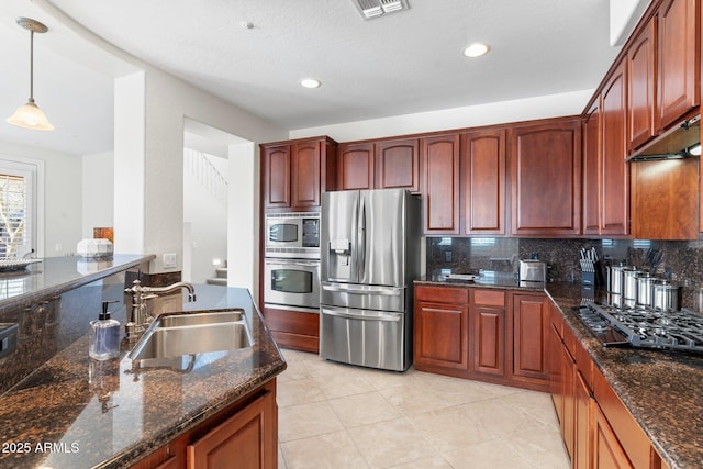 kitchen featuring hanging light fixtures, backsplash, sink, and appliances with stainless steel finishes