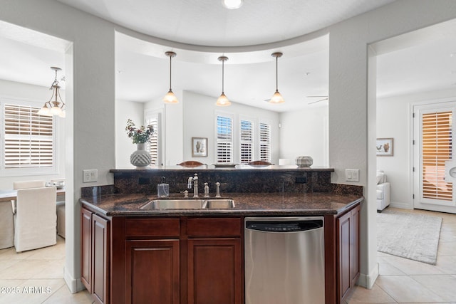 kitchen featuring sink, dark stone counters, hanging light fixtures, and dishwasher