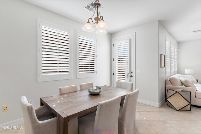 tiled dining room featuring a notable chandelier