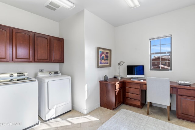 laundry room featuring light tile patterned flooring, cabinets, and washing machine and dryer