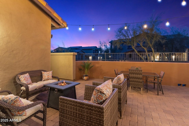 patio terrace at dusk featuring an outdoor living space with a fire pit