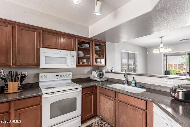 509 S 111th Dr, Avondale, AZ 85323 - kitchen with white appliances, dark countertops, a chandelier, and brown cabinetry