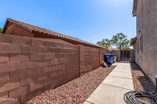 509 S 111th Dr, Avondale, AZ 85323 - view of home's exterior featuring a fenced backyard, a gate, a tile roof, and stucco siding