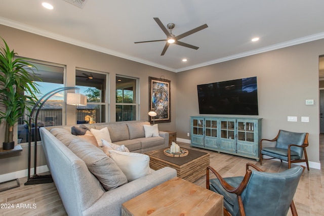 living room featuring light hardwood / wood-style floors, crown molding, a fireplace, and ceiling fan