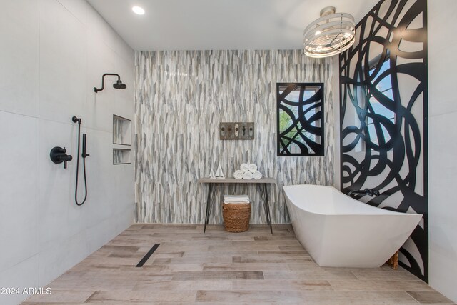 bathroom featuring hardwood / wood-style flooring, tile walls, and separate shower and tub