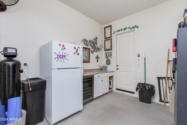 kitchen with wine cooler, white cabinets, and white refrigerator