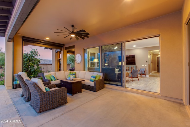 patio terrace at dusk with an outdoor living space and ceiling fan