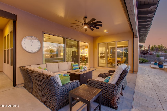 patio terrace at dusk with an outdoor living space and ceiling fan