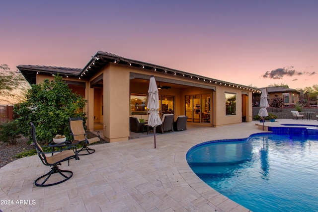 pool at dusk featuring a patio