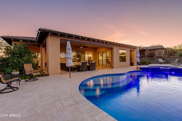 pool at dusk featuring a patio