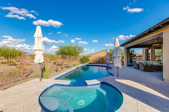 view of pool with an in ground hot tub, an outdoor living space, a patio area, and ceiling fan