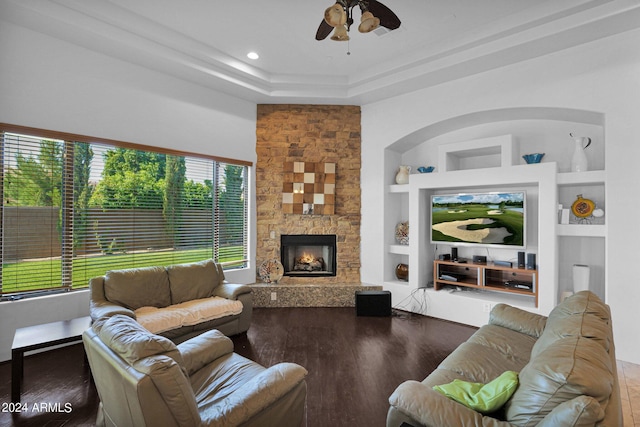 living room featuring ceiling fan, a fireplace, hardwood / wood-style floors, and built in features