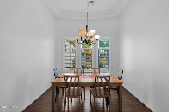 dining room featuring a notable chandelier, dark hardwood / wood-style flooring, and a tray ceiling