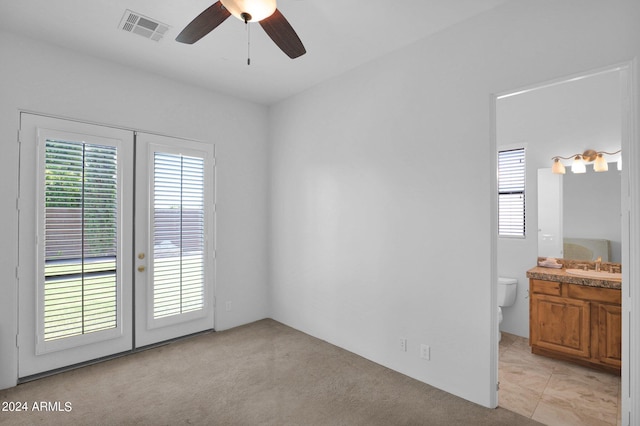 carpeted spare room with french doors, ceiling fan, and sink