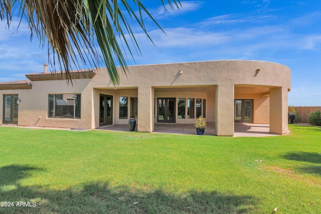 rear view of property with a patio and a lawn