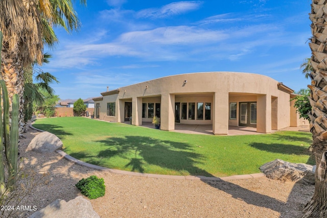 rear view of property featuring a patio area and a lawn