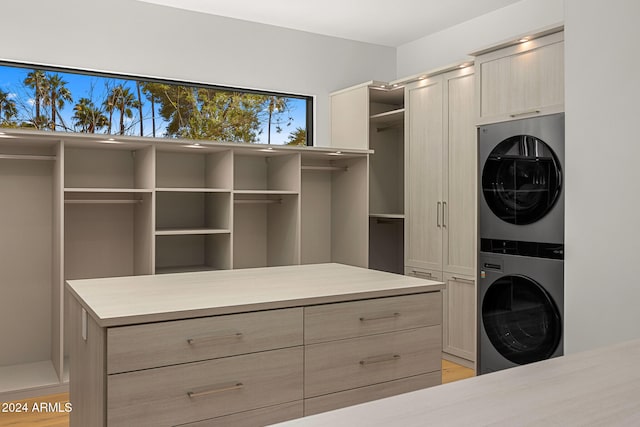 interior space with light hardwood / wood-style flooring, cabinets, and stacked washer / dryer