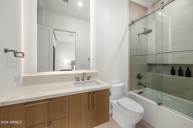 full bathroom with shower / bath combination with glass door, tile patterned floors, toilet, and vanity